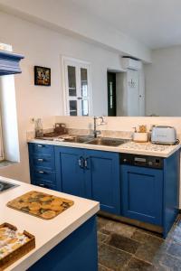 a kitchen with blue cabinets and a sink at Stellinas House 2 in Andros +12 photos