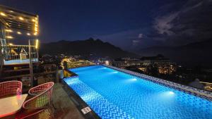 a swimming pool on top of a building at night at Azalea Sapa Hotel in Sapa