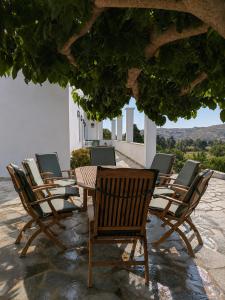 a row of chairs and tables on a patio at Stellinas House 2 in Andros