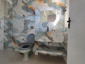 a bathroom with a toilet and a wall mural at Quarto Califórnia in Campo Novo do Parecis +25 photos