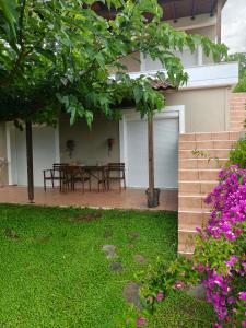 a house with a patio with a table and flowers at Eveline house in Larisa +2 photos
