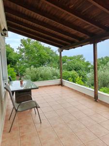 a patio with a table and a chair on it at Eveline house in Larisa