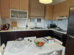 a kitchen with a bowl of fruit on a table at Eveline house in Larisa