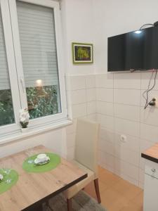 a small kitchen with a wooden table and a window at Apartman studio DUE Apatin in Apatin