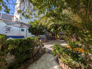 a patio with a table and an umbrella and trees at Orange3 Hostel in Lagos