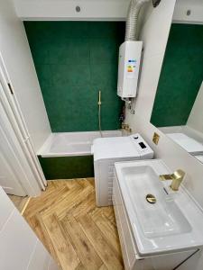 ein Badezimmer mit einem weißen Waschbecken und einer Badewanne in der Unterkunft Studio - Polna in Końskie