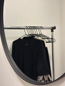 a black shirt on a rack in front of a mirror at Bright Apartment with Forest View Balcony in Naujoji Akmenė