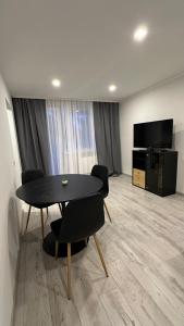 a room with a table and chairs and a flat screen tv at Bright Apartment with Forest View Balcony in Naujoji Akmenė +9 photos