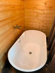 a white bath tub in a room with wooden walls at Cottage lima in Kutaisi