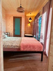 a bedroom with a bed in a wooden cabin at Cottage lima in Kutaisi