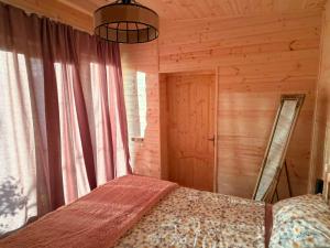 a bedroom with a bed in a wooden cabin at Cottage lima in Kutaisi