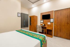 a bedroom with a bed and a desk and a television at Treebo Ayodhya Grand in Madnāpur