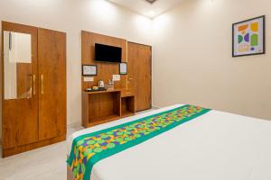 a bedroom with a bed and a tv and a bedskirtspectspectspectspects at Treebo Ayodhya Grand in Madnāpur