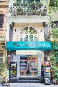 a store with a blue sign in front of a building at Ha Noi Capital Boutique Hotel in Hanoi