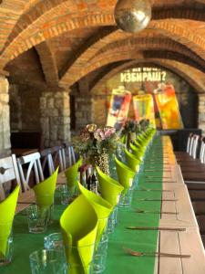 a long table with green chairs and flowers on it at Hipodruma Resort & Pool in Dobrich