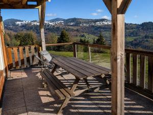 a wooden bench sitting on top of a porch at Le Panorama in Soultzeren