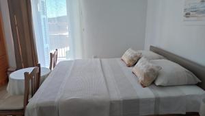 a bedroom with a bed with pillows and a window at Apartment Tacoma in Vrsar