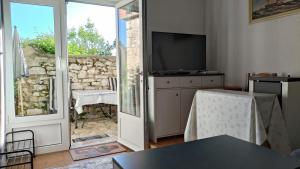 a living room with a television and a sliding glass door at Apartment Tacoma in Vrsar