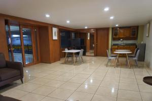 ein Wohnzimmer mit Tischen und Stühlen und eine Küche in der Unterkunft Hotel Real Alteño in Tepatitlán