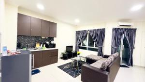 a kitchen and living room with a couch and a table at Desaru Coastline Cribs in Bandar Penawar