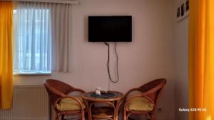 a room with a table and two chairs and a tv at Pension Yammas in Großpostwitz