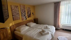 a bedroom with a bed with towels on it at Pension Yammas in Großpostwitz