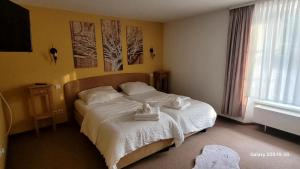 a bedroom with a bed with towels on it at Pension Yammas in Großpostwitz