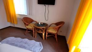 a room with a table and two chairs and a television at Pension Yammas in Großpostwitz +1 photo