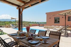 a wooden table with food on top of a patio at Stavlos Villa - Private Pool in episkopi-heraklion