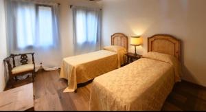 a hotel room with two beds and a window at Mercerie e Capitello Apartments in Venice