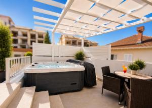a hot tub on a patio with a table and chairs at Golden horizon Cavtat in Cavtat