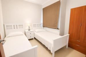 a bedroom with two beds and a wooden cabinet at OPEN SKY VALLEY in Mogán