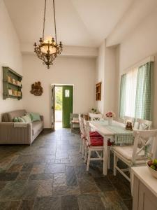 a dining room and living room with a table and chairs at Stellinas Pretty House in Andros