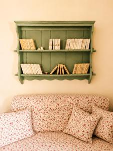 a green shelf above a couch with books on it at Stellinas Pretty House in Andros