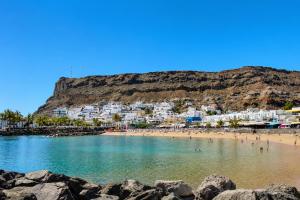 a beach with a bunch of people in the water at OPEN SKY VALLEY in Mogán +4 photos