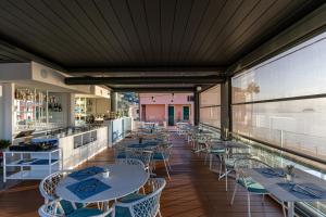 a restaurant with tables and chairs and a bar at Acciuga Hotel in Laigueglia