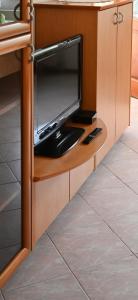a tv sitting on a shelf in a kitchen at Apartma Kukč II in Bovec