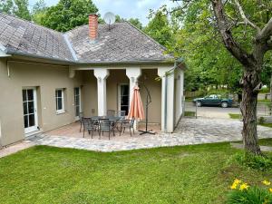 a house with a patio with a table and chairs at Giulia Vendégház in Balatonboglár