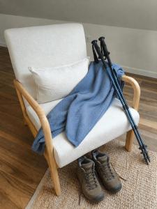 a rocking chair with a blanket and a pair of shoes at Lembranza Guest House in Ponte Do Porto