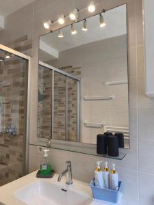 a bathroom with a sink and a large mirror at Maddalena House in Varenna