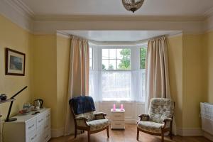 a living room with two chairs and a window at Cenotaph View, Bardon Mill in Hexham
