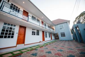 a building with red doors and a balcony at Heaven Hill Apartment in Arusha