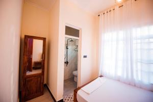 a bedroom with a bed and a bathroom with a shower at Heaven Hill Apartment in Arusha
