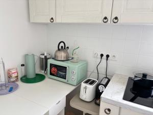 a kitchen counter with a tea kettle on top of a microwave at New,mountain & sea view 3 guests with private Garage in Beausoleil +6 photos