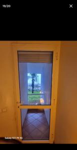 a door with a window with a view of a tree at jardin de raisin in Bouznika +2 photos