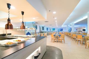 a restaurant with tables and chairs and a buffet at Hotel Floresta in Puerto del Carmen