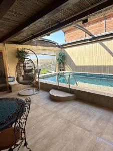 a swimming pool with a table and chairs next to a pool at צימר בוטיק אדלה Zimmer boutique adela in Arad