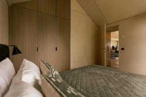 a bedroom with a bed with a large mirror at Lėtai resort, Lakefront Nature Stay with Sauna in Eželiškės