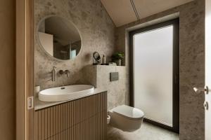 a bathroom with a sink and a toilet and a mirror at Lėtai resort, Lakefront Nature Stay with Sauna in Eželiškės +49 photos