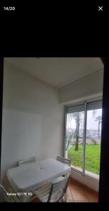 a white room with a large window and a bed at jardin de raisin in Bouznika